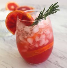 a glass filled with ice and garnish next to an orange slice