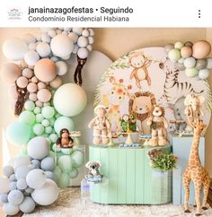 a baby's first birthday party with balloons and stuffed animals on the table, including giraffes