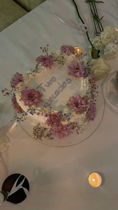 there is a cake with flowers and candles on the table