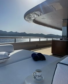 the sun shines brightly on a boat deck with pillows and slippers sitting on it