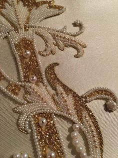 an embroidered piece with pearls and beads on it