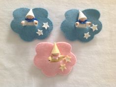 three small toy items on top of a white towel with blue clouds and stars in the background