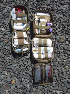 two open suitcases sitting on top of a rocky ground