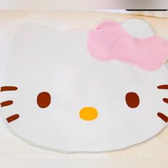 a hello kitty mat with a pink bow on it's head is shown in front of a white background