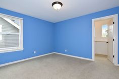 an empty room with blue walls and white trim