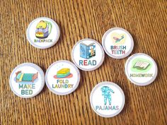 six badges that say, make bed, read, and have been placed on a table