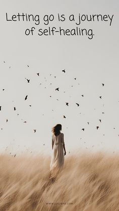 a woman standing in the middle of a field with birds flying above her and text that reads letting go is a journey of self - healing