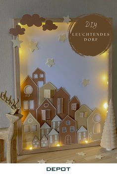 the diy lighted christmas village is displayed on top of a wooden shelf with lights