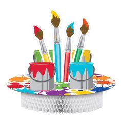 a cupcake with paintbrushes sticking out of it