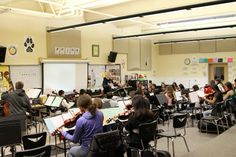 a group of people playing instruments in a classroom