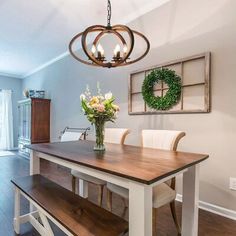 a dining room table with chairs and two hanging lights