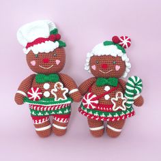 two crocheted gingerbread man and woman dolls with candy canes in their hands