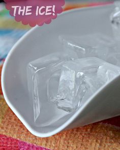 ice cubes in a white bowl on a colorful tablecloth with the words, the ice