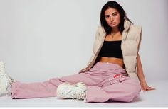 a woman sitting on the ground wearing pink sweatpants