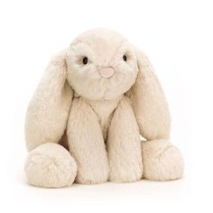 a white stuffed rabbit sitting up against a white background