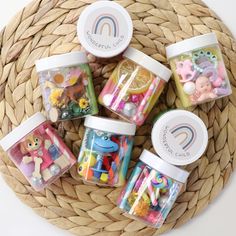 small jars filled with different types of candies and toys on top of a wicker basket