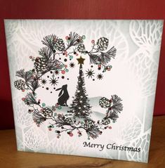 a white christmas card with an image of a tree and snowflakes on it