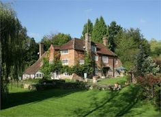 a large brick house surrounded by trees and grass