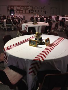 a round table with white and red cloths on it is set up for an event