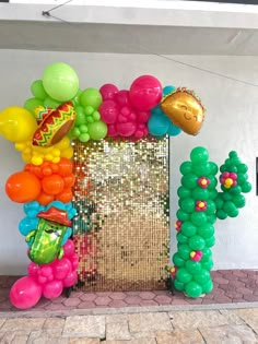 an arch made out of balloons and confetti on the side of a building