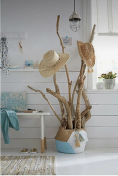 a white room with some hats on top of the branches and a rug in front of it