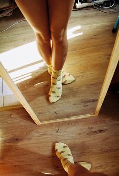 a person standing in front of a mirror wearing socks