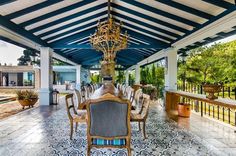 an outdoor dining area with blue and white tile flooring, chandelier hanging from the ceiling