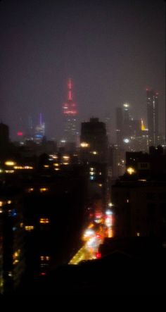 the city skyline is lit up at night, with bright lights on it's skyscrapers