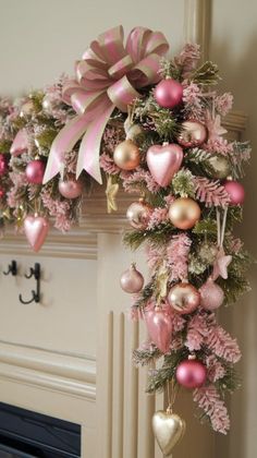 pink and gold christmas decorations hanging from a fireplace mantel