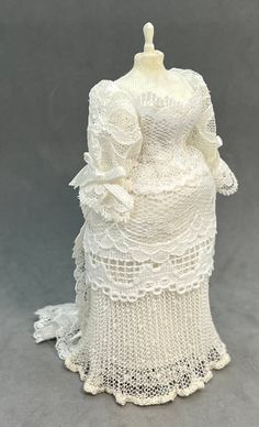 a white crochet dress on a mannequin with lace around the bust