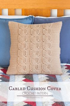 a crocheted cushion cover on a bed with blue and white quilted pillows