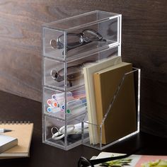 a clear acrylic holder holds books, glasses and other office supplies on a desk