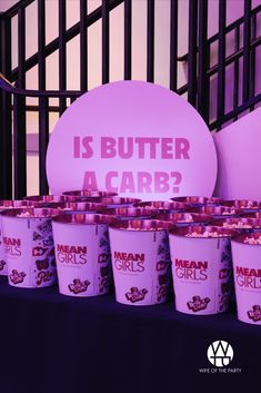 ice cream cups with pink frosting are lined up in front of a sign that says is butter a carb?