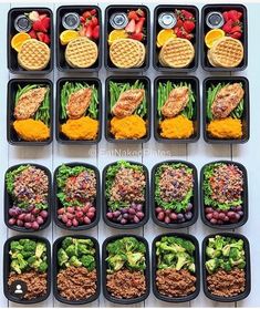 a table topped with black trays filled with different types of food and veggies