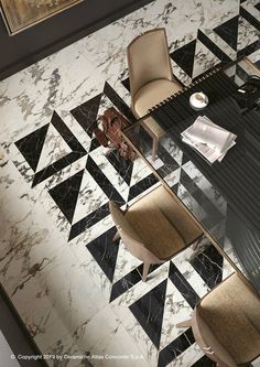 a glass table with chairs and pictures on the wall behind it in an elegant dining room