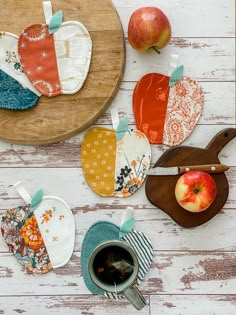 an assortment of kitchen gadgets laid out on a white wooden table with apples and tea