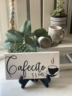 a sign that says cafeto time on it next to some coffee cups and plants