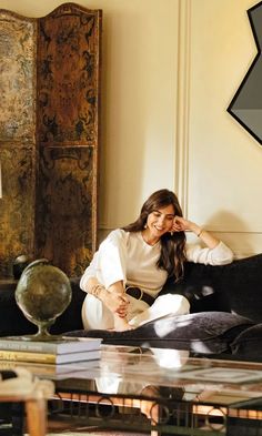 a woman sitting on top of a black couch