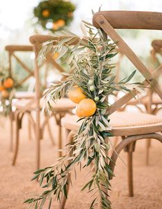 an olive branch hangs from the back of a chair with oranges and leaves on it