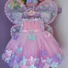 a teddy bear wearing a pink dress with butterflies on it's chest and wings