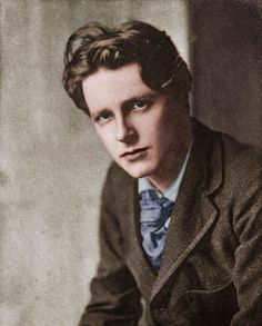 an old photo of a man in a suit and tie sitting at a table with his hands on his knees