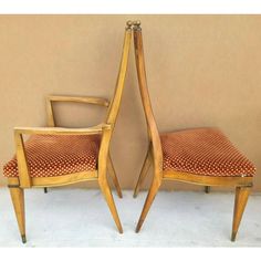 two wooden chairs sitting next to each other on top of a white carpeted floor