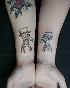 two people with matching tattoos on their arms, one has a bird and the other has a man's face