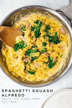 a skillet filled with scrambled eggs and spinach on top of a white counter