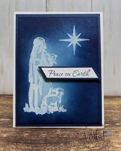 a christmas card with a nativity scene and star on the sky in white ink