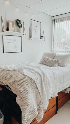 a bedroom with a bed, window and pictures on the wall