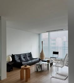 a living room filled with furniture next to a tall glass window covered in lots of windows