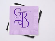 two purple napkins with the word congratulations written in black and white on them, sitting next to each other