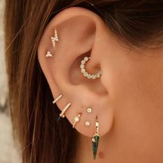 a woman wearing ear piercings with different designs