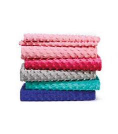 five towels stacked on top of each other in different colors and patterns, with one folded up